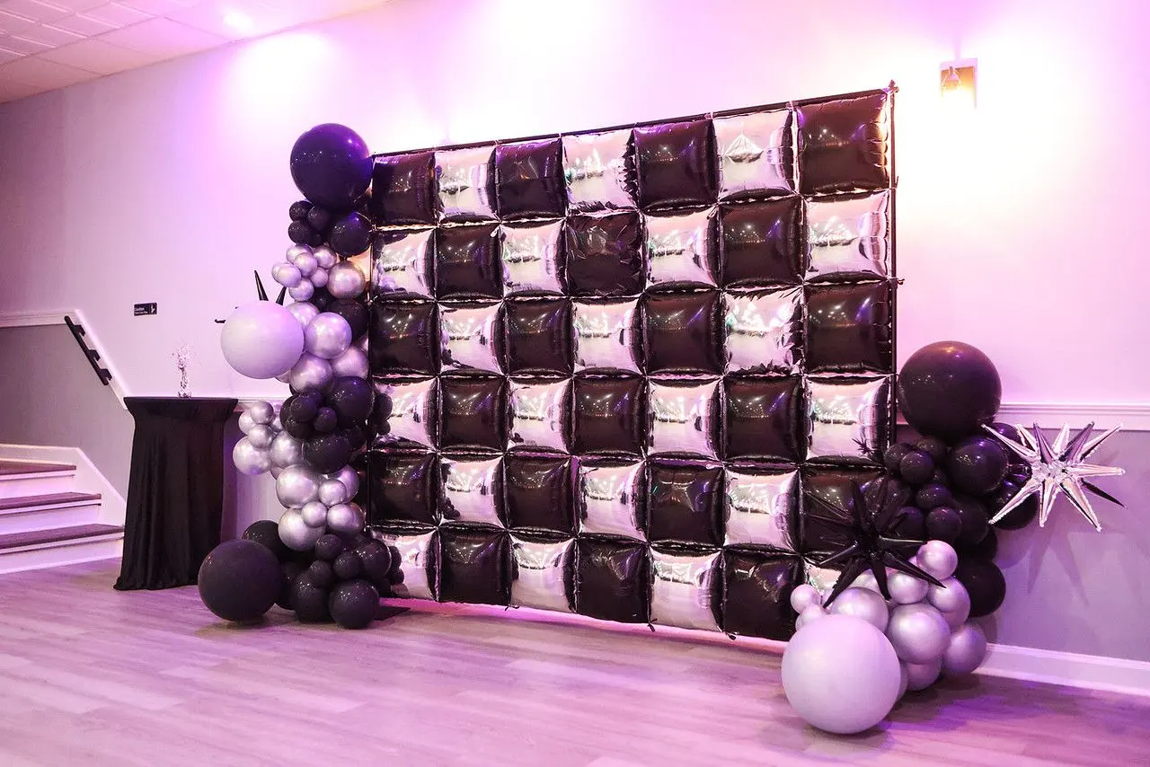 Black and white balloon backdrop with a gold star at a prom night at The Heights