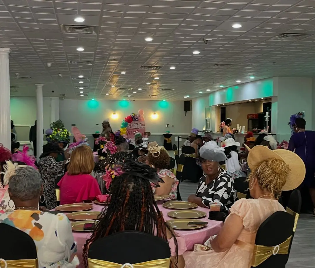 Guests at a daytime banquet with gold chair sashes at The Heights