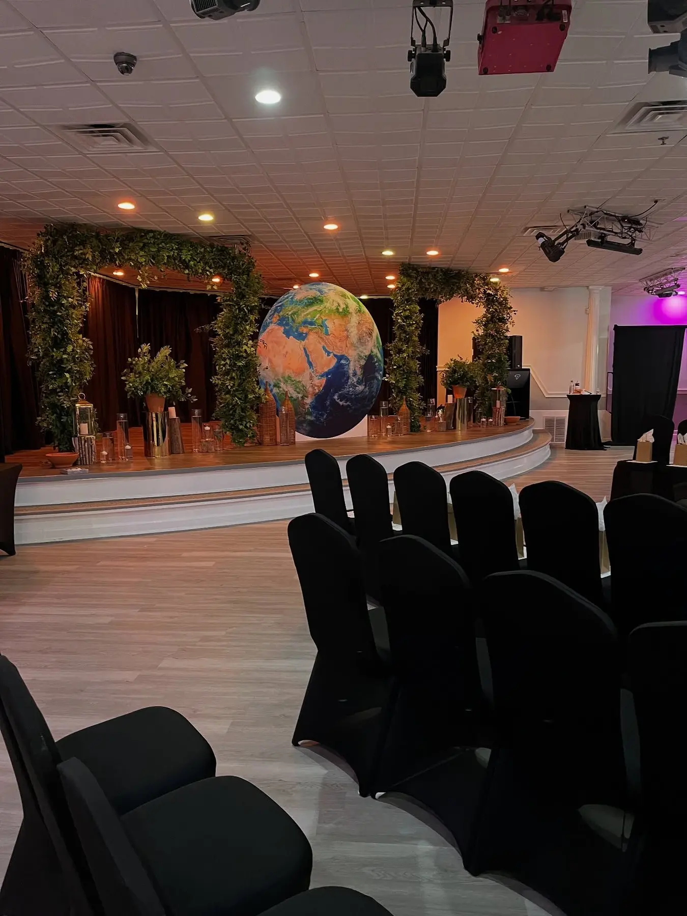 Rows of black chairs facing the greenery wall at The Heights, ceremony layout