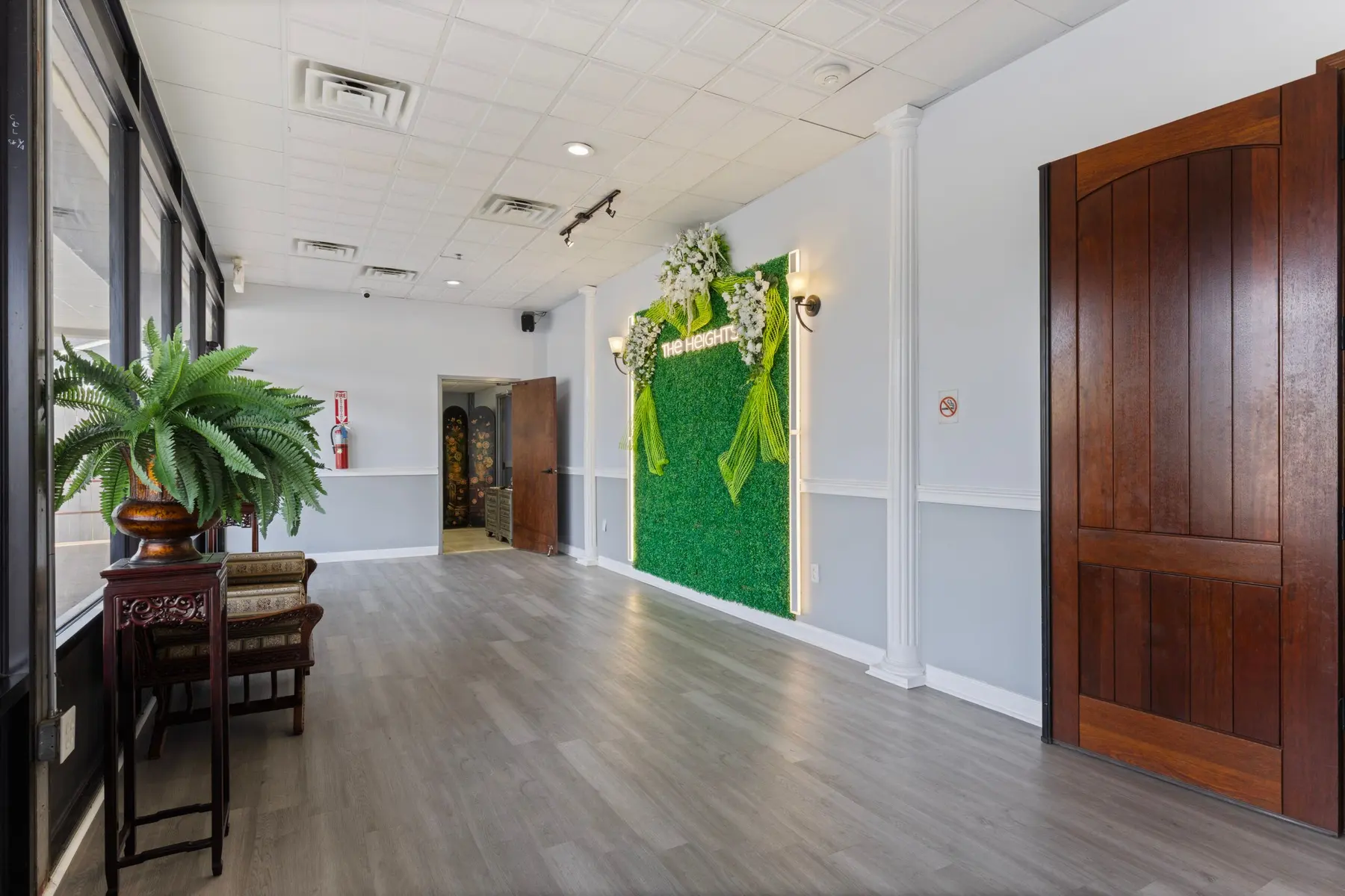 The open hall with the greenery photo wall and wood floors at The Heights