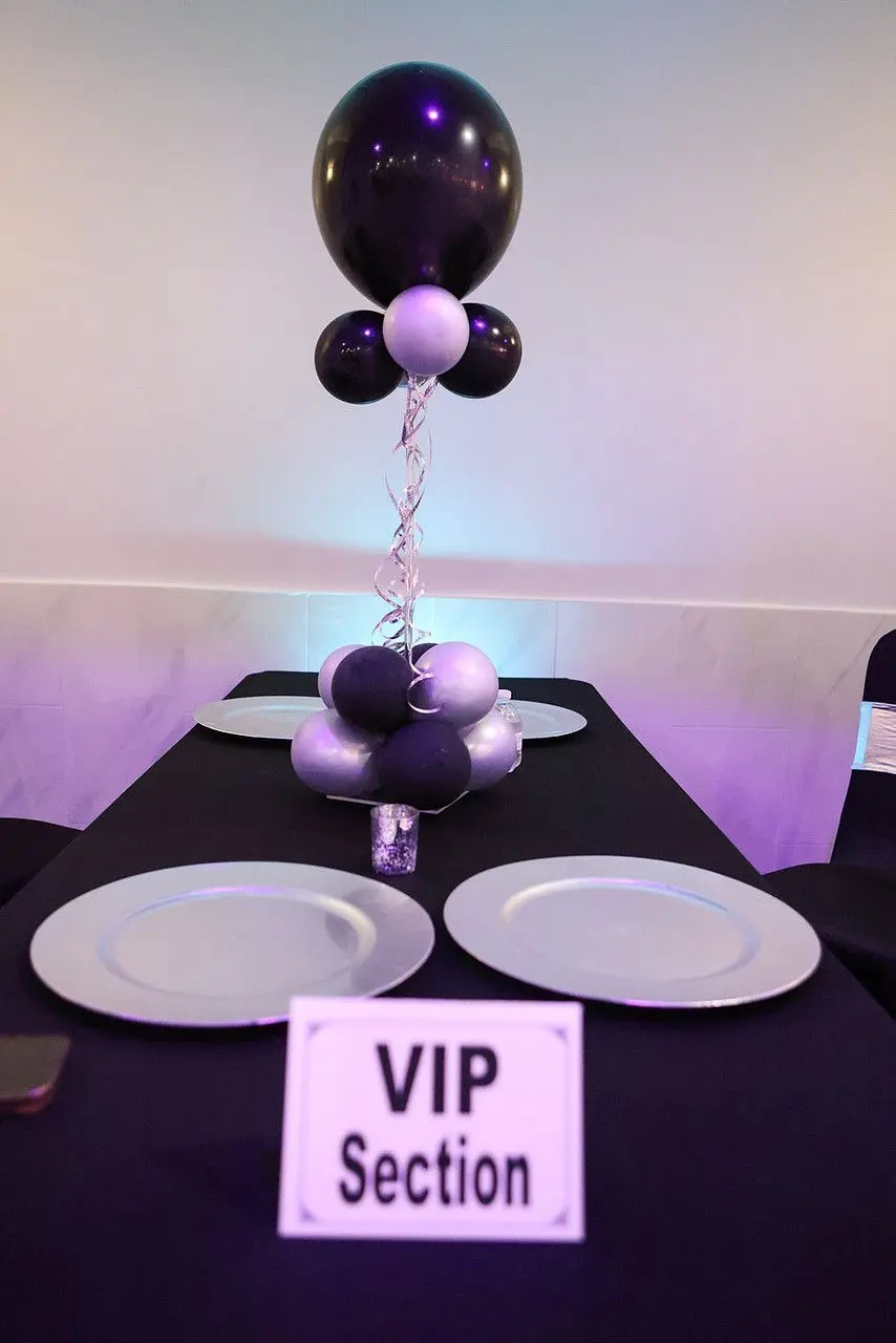 A VIP section table with black linens and a balloon centerpiece at The Heights